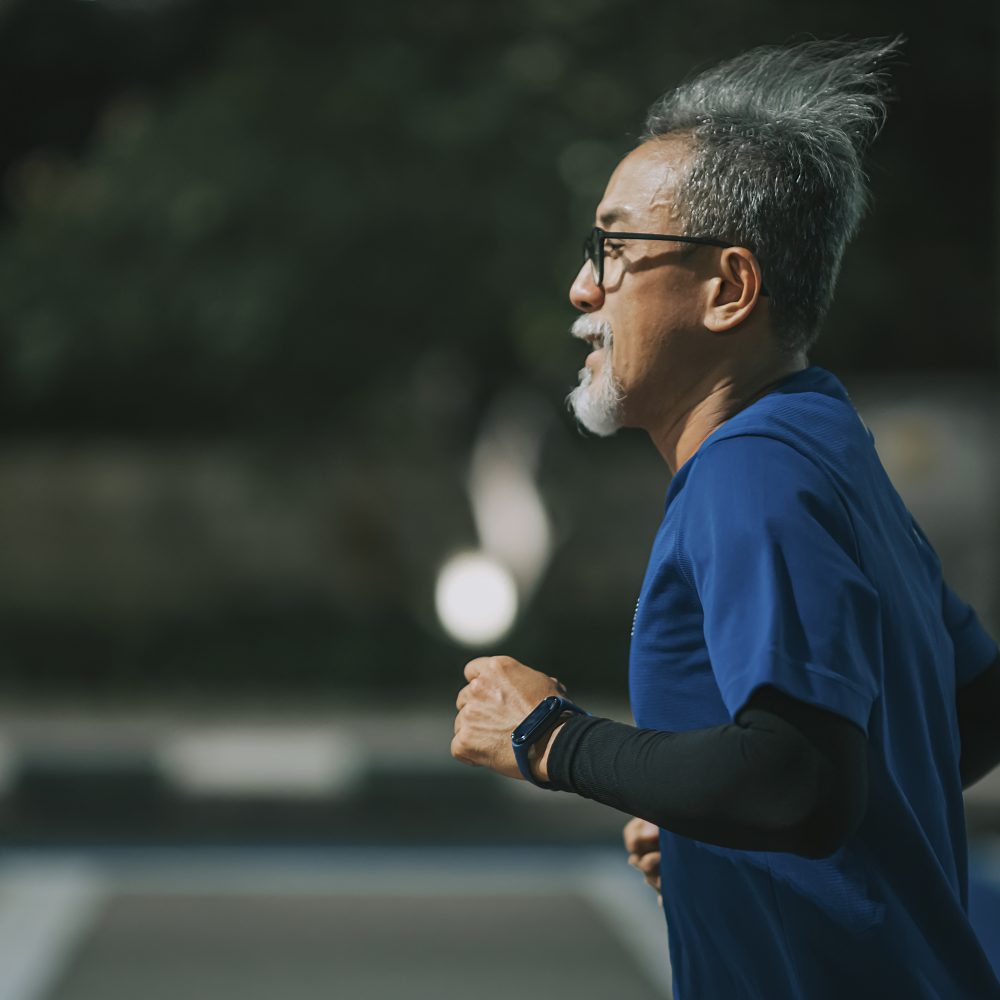 Senior man running on city street.