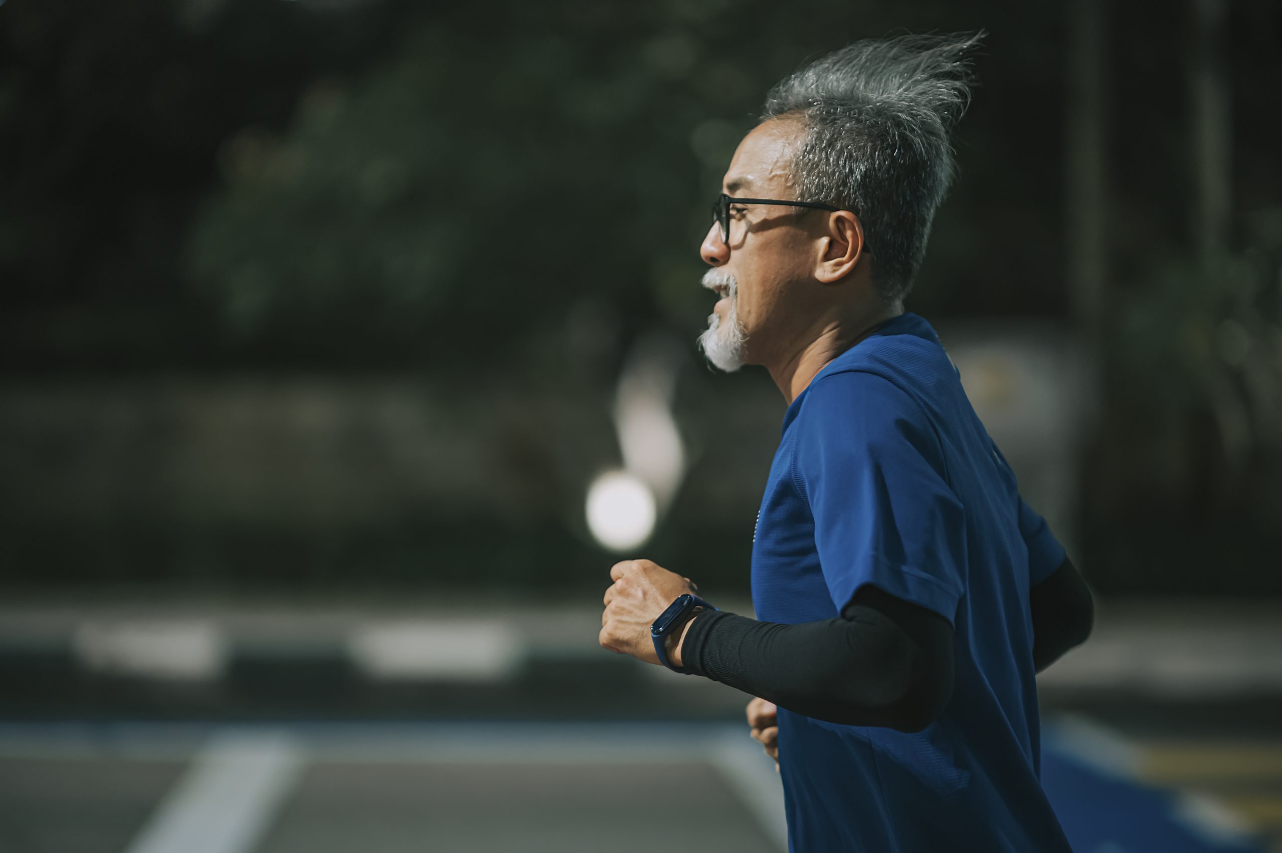 Senior man running on city street.