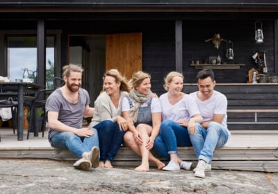 Five persons sitting on terrace.