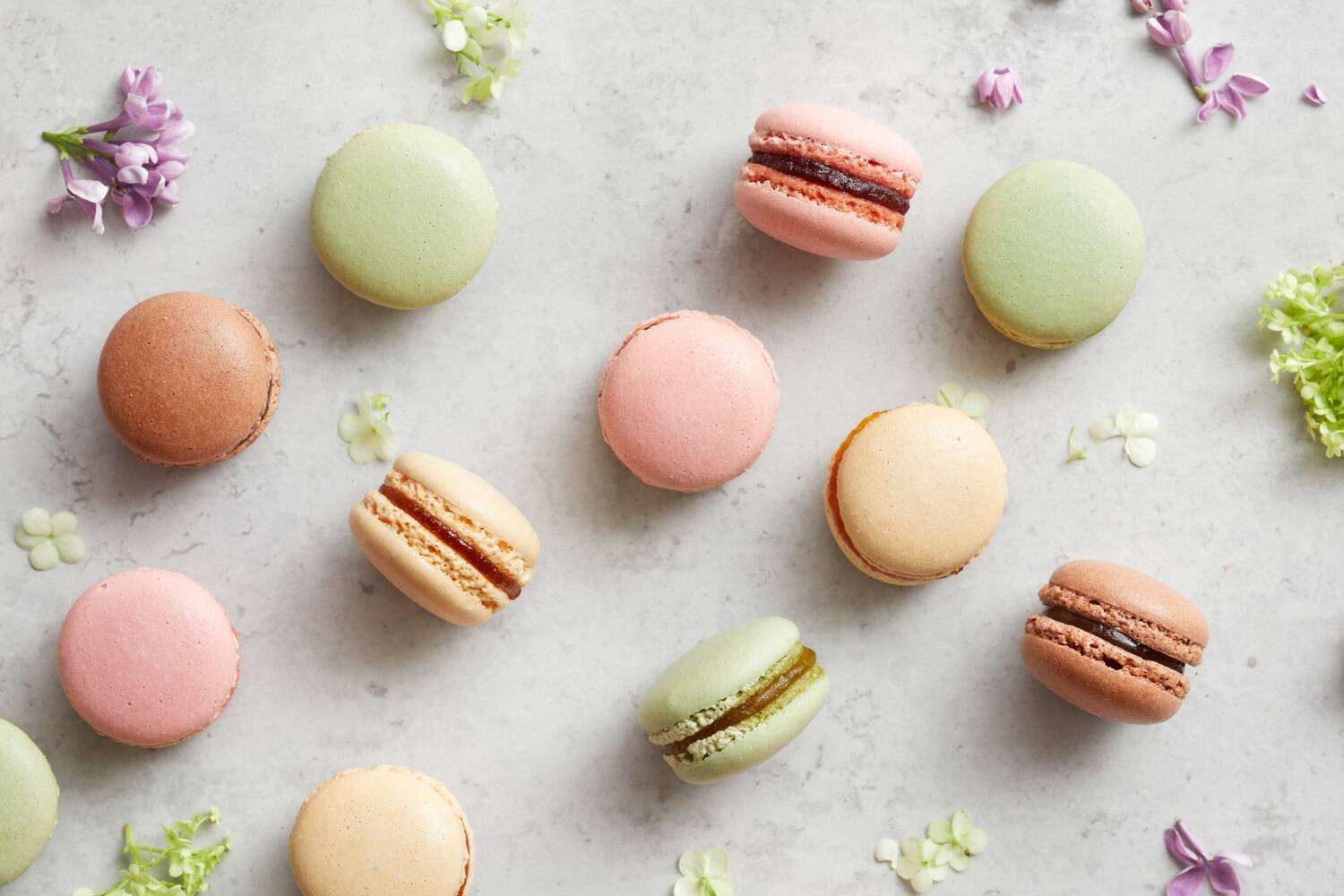 Eri värisiä macarons leivoksia pöydällä.