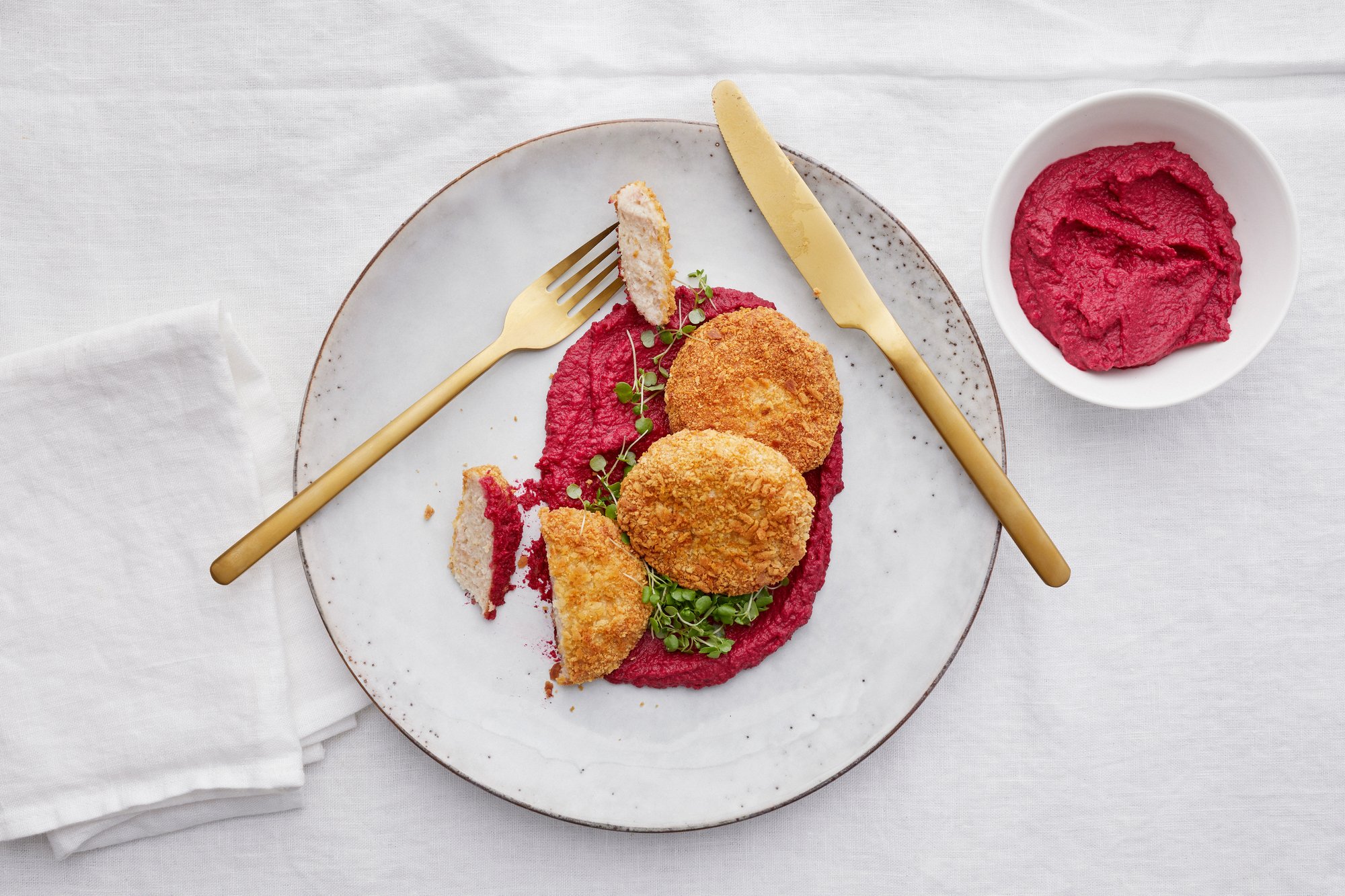 Ylhäältä päin kuvattu kuvattu, jossa broilerimurekepihvejä. Lautasen pohjalla on punaista rosollitahnaa, joka löytyy myös omasta kipostaan.