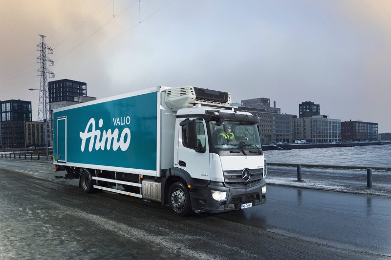 Kuvassa talvisessa Helsingin maisemassa on Valio Aimo rekka-auto kuvattuna sivuttain ajamassa eteenpäin tiellä.