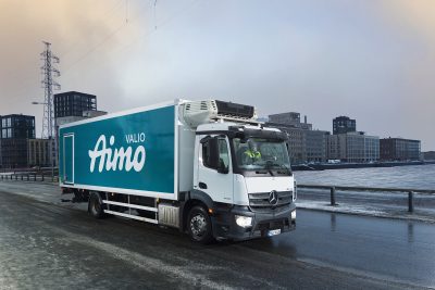 Kuvassa talvisessa Helsingin maisemassa on Valio Aimo rekka-auto kuvattuna sivuttain ajamassa eteenpäin tiellä.