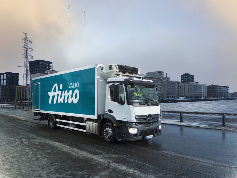 Kuvassa talvisessa Helsingin maisemassa on Valio Aimo rekka-auto kuvattuna sivuttain ajamassa eteenpäin tiellä.