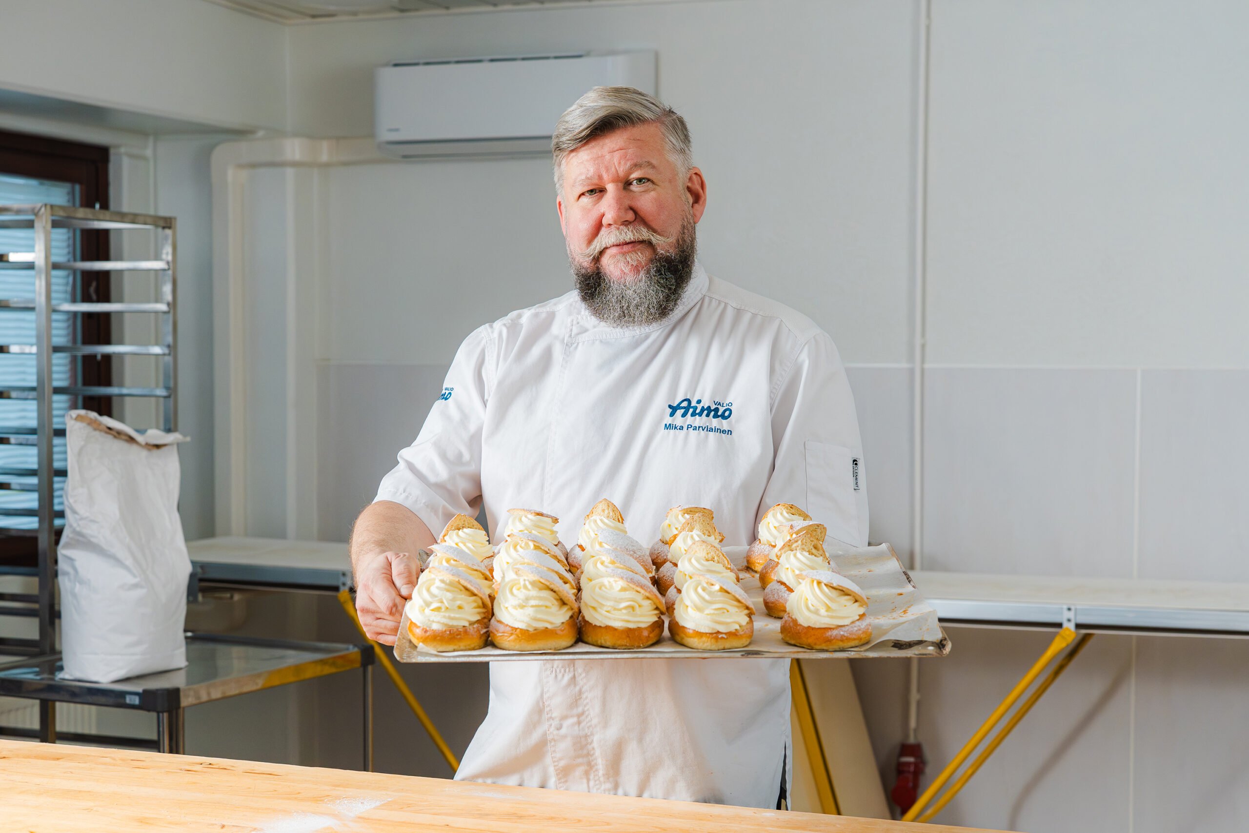 Leipomokonsultti Mika Parviainen näyttää pellillä olevia valmiita laskiaispullia