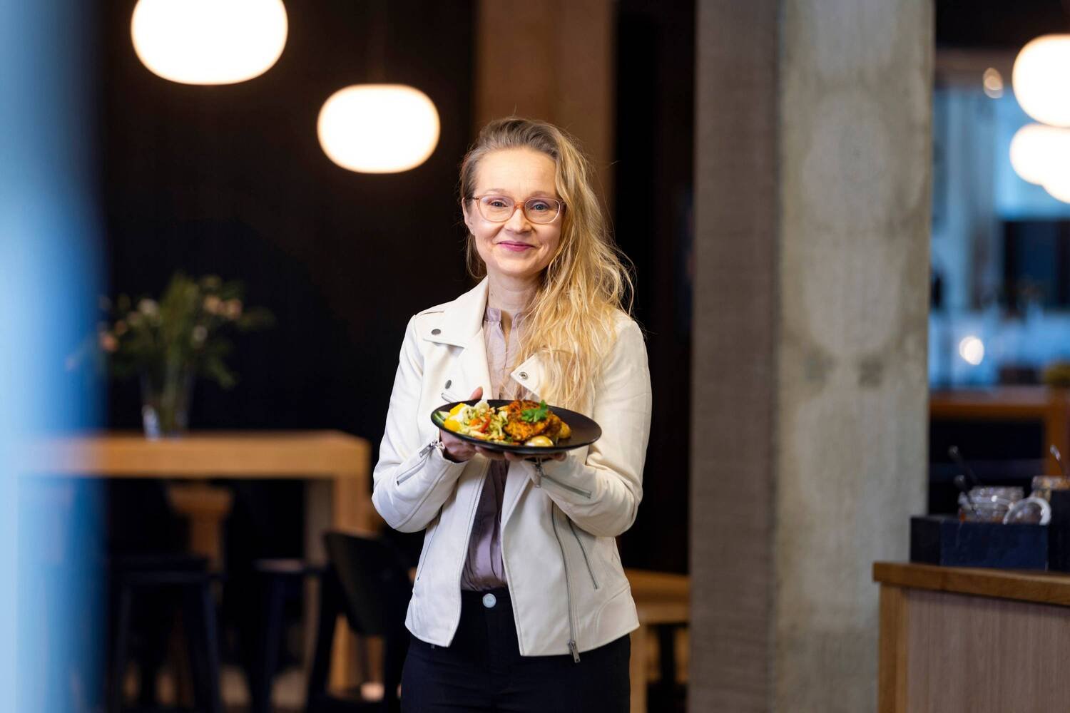 Nina Lyytinen esittelee lautasannosta ravintolassa