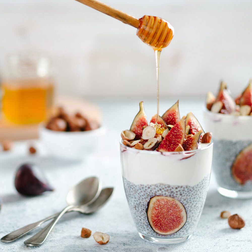 Chiapudding with yoghurt, figs and nuts in a glass.